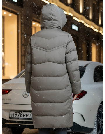 Длинный женский пуховик с капюшоном.
