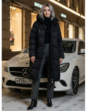 Длинный женский пуховик с капюшоном.